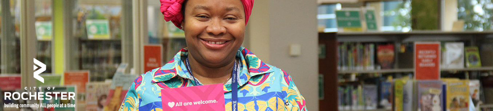 woman holding library card and smiling at camera