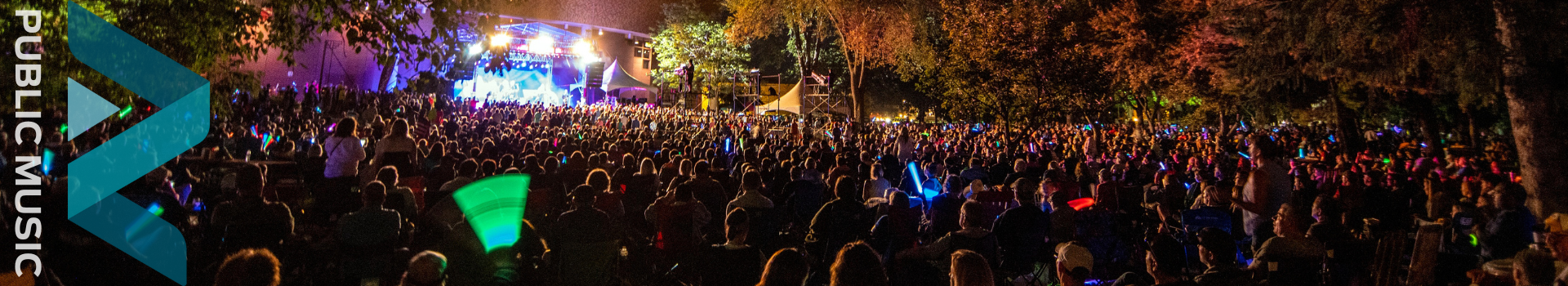 Banner of a fall evening concert with crowds of people watching the performers on stage.