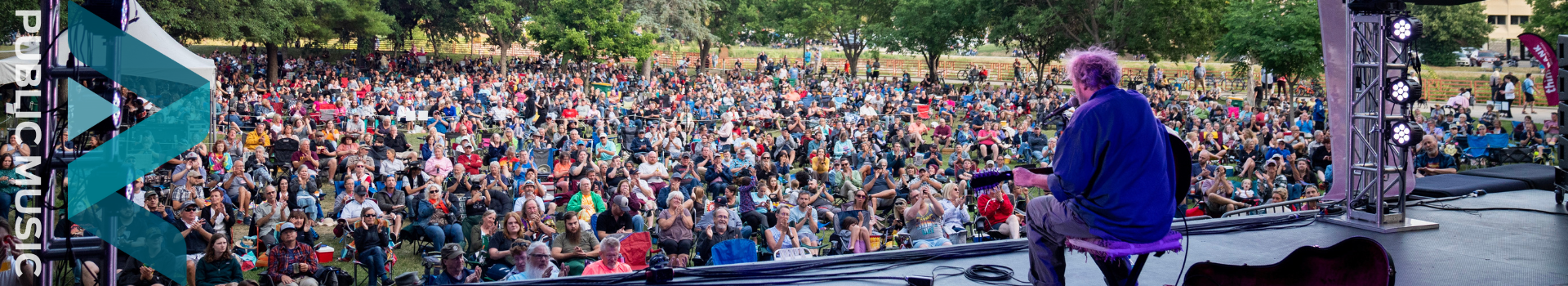 Banner of a large crowd of people watching a concert.